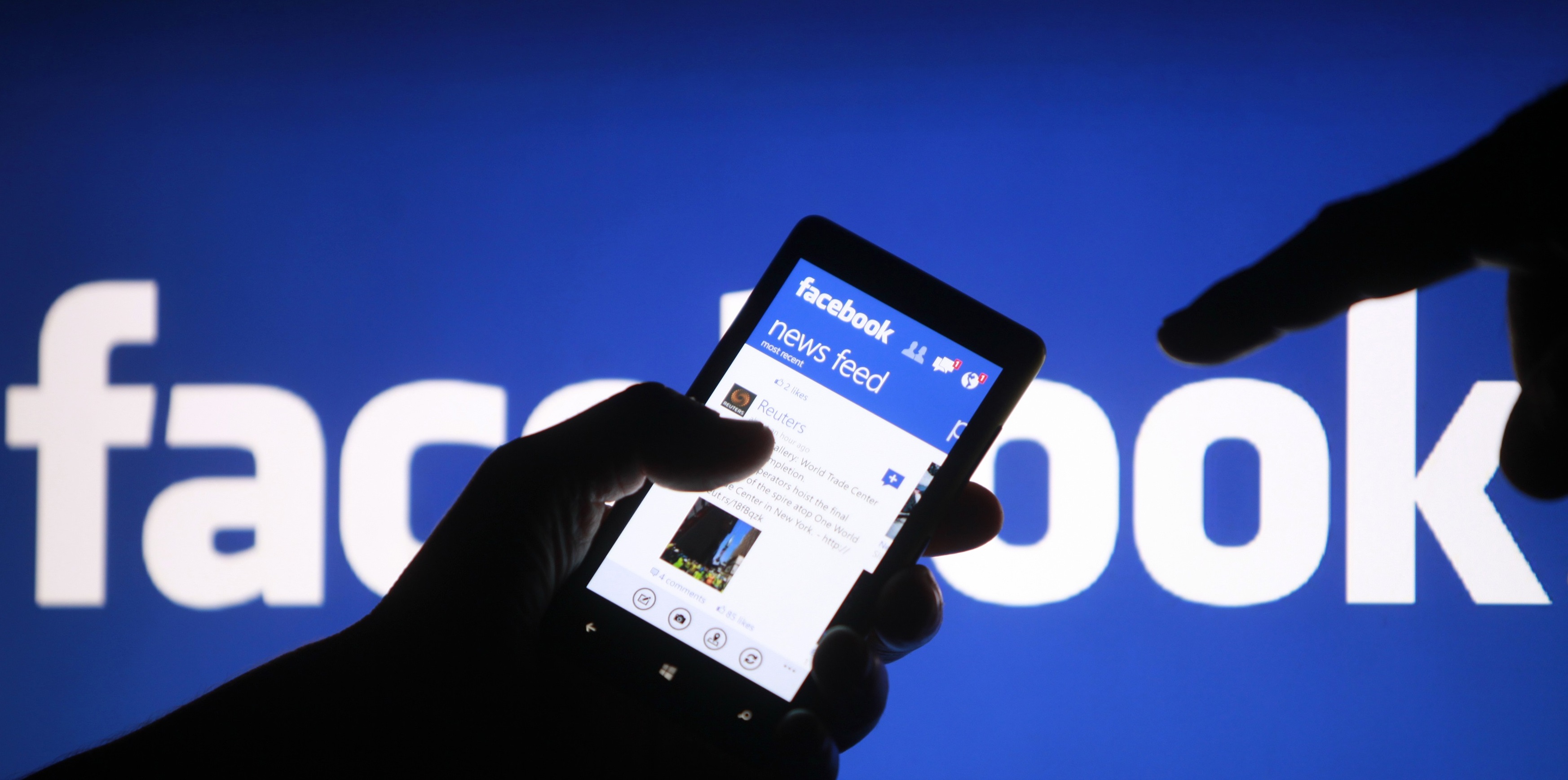 A smartphone user shows the Facebook application on his phone in the central Bosnian town of Zenica, in this photo illustration, May 2, 2013. Facebook Inc said July 24, 2013 that revenue in the second quarter was $1.813 billion, compared to $1.184 billion in the year ago period. REUTERS/Dado Ruvic /Files (BOSNIA AND HERZEGOVINA - Tags: SOCIETY SCIENCE TECHNOLOGY BUSINESS)